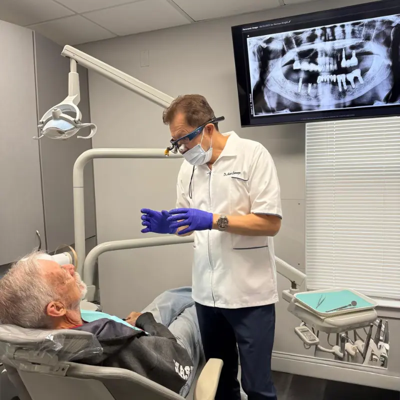 Dr. Aristo Carranza, equipped with professional dental loupes, discusses a treatment plan with a patient at Smile Design NJ