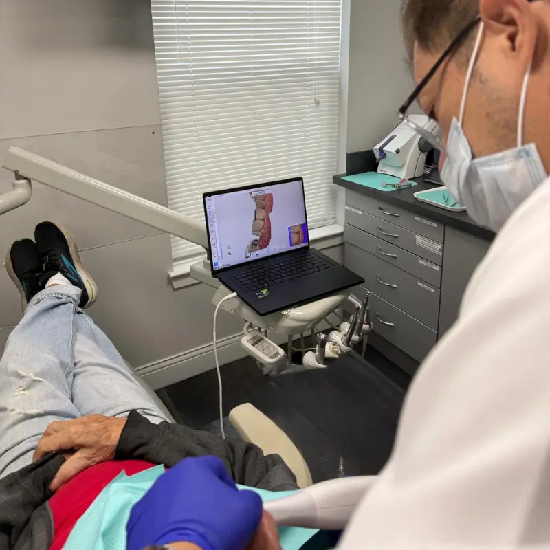 Dr. Carranza, cosmetic dentist at Smile Design NJ in Westfield, NJ, analyzes a patient's 3D digital dental scan during an examination